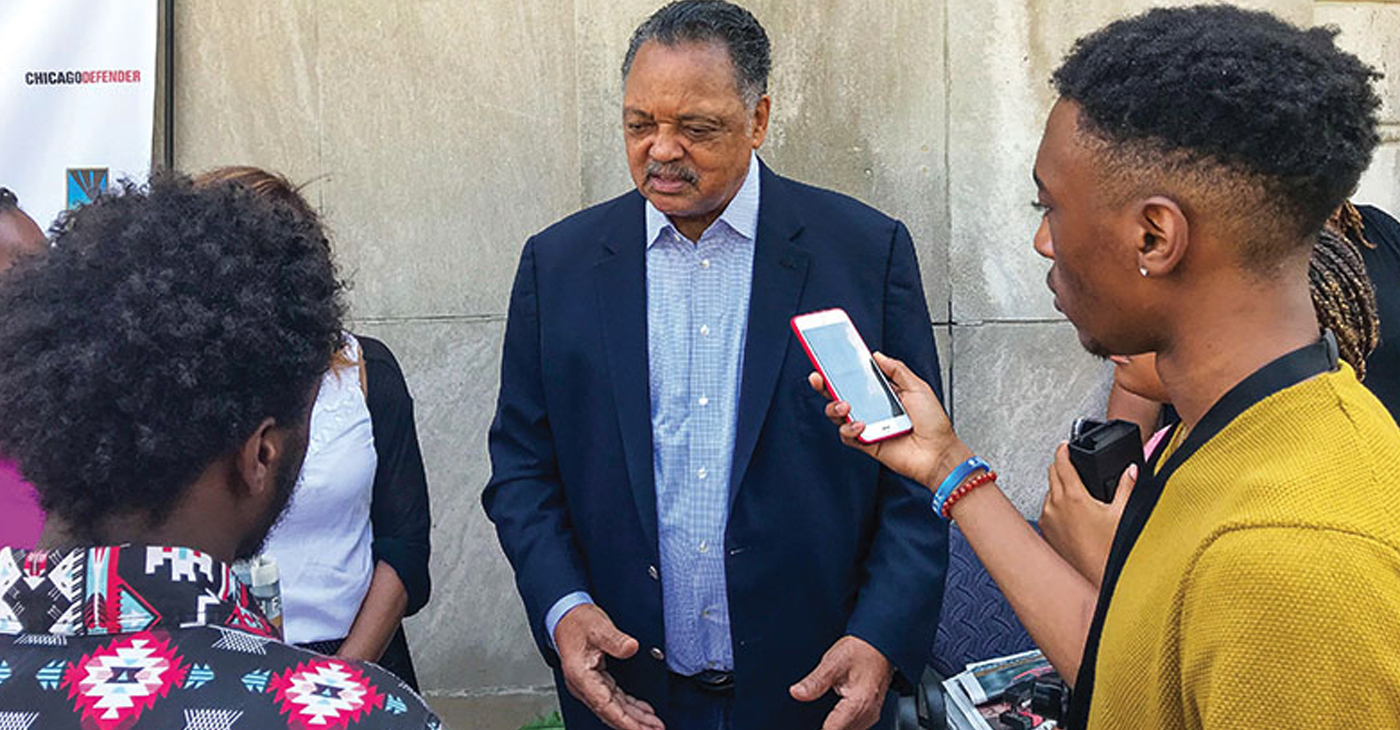 CRUSADER SUMMER INTERN Elae Hill (far right) records an unexpected interview with Reverend Jesse Jackson at the Chicago Defender’s offices on July 10. Jackson visited the newspaper as it published its last edition. The publication will now be digital only.
